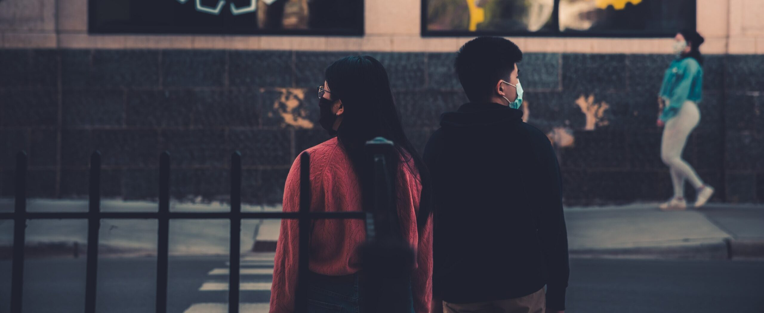 Young couple stood in the street looking in opposite directions